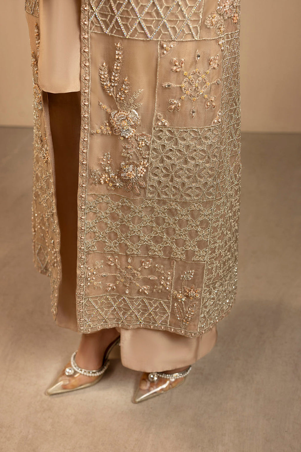 "Focus on sleeve cuffs and hemline patch borders of Motifz 0076 Arisha organza suit, displaying multi-textured embroidered borders and precision boutique tailoring."