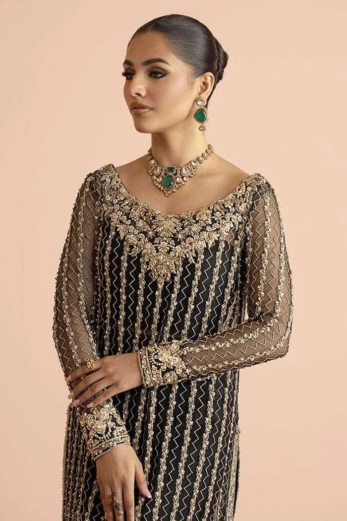 "Detailed view of the wide-leg Azaar trousers with gold embroidered border trims paired with Vera black shirt."