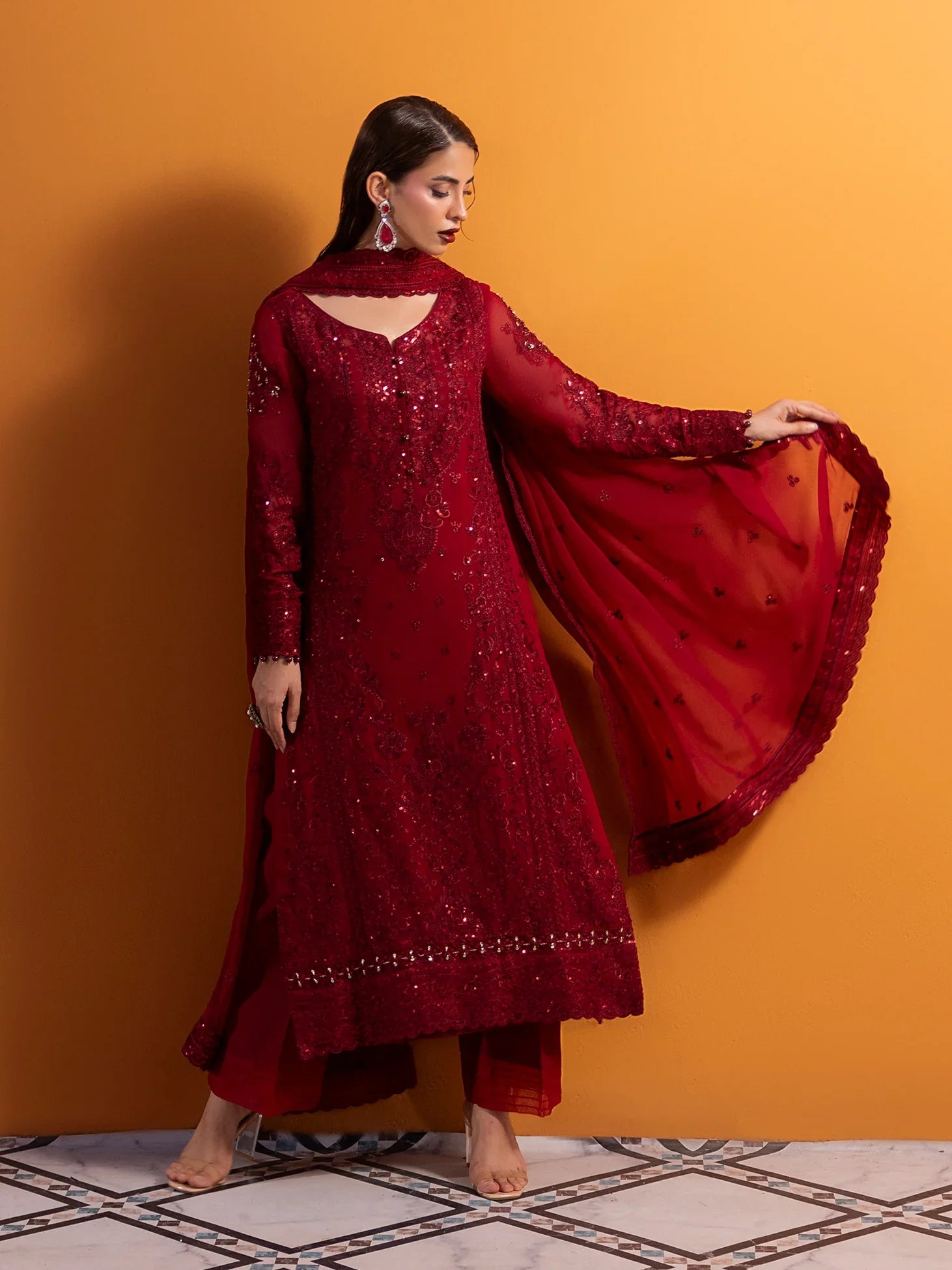 "Focus on the intricate sleeve cuff trimmings and lace hemline details of the Gulaal Crimson stitched luxury suit, showing boutique-quality tailoring."