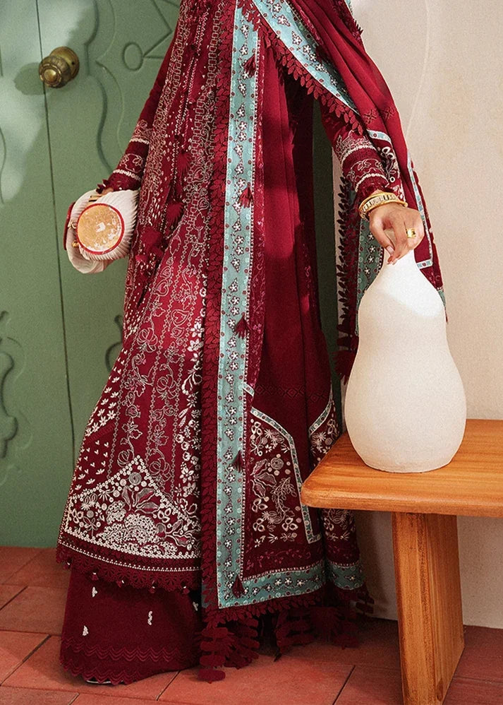 "Detailed view of embroidered daman borders and tailored cambric trousers on Suffuse Ineesa red lawn suit."