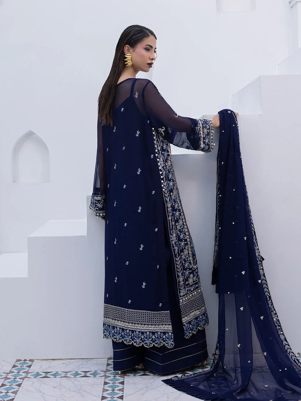 "Focus on the intricate sleeve cuff trimmings and lace hemline details of the Gulaal Lueur stitched luxury suit, showing boutique-quality tailoring."
