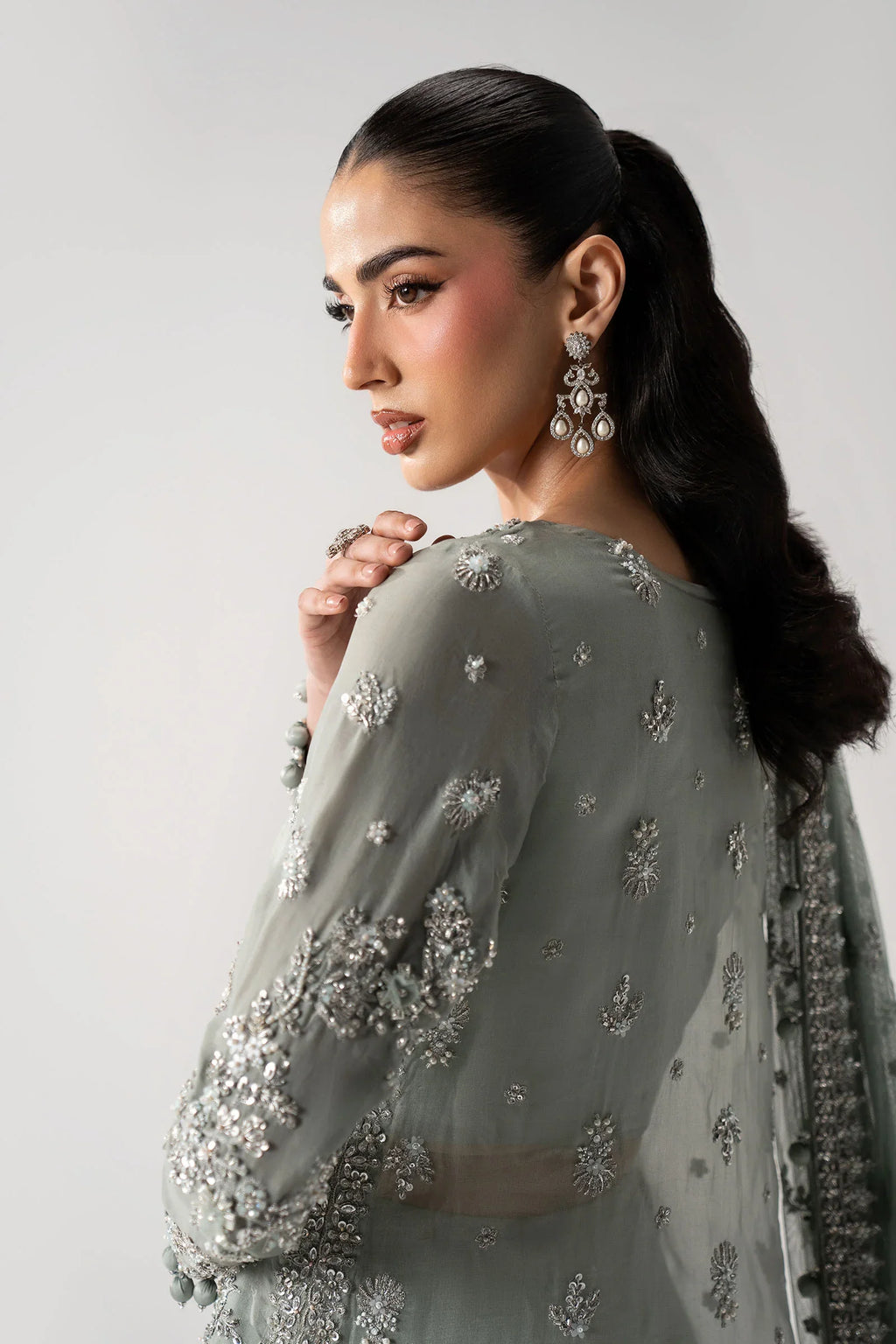 "Detailed view of ornate embroidered organza borders attached to the velvet shirt hemline and sleeve cuffs."