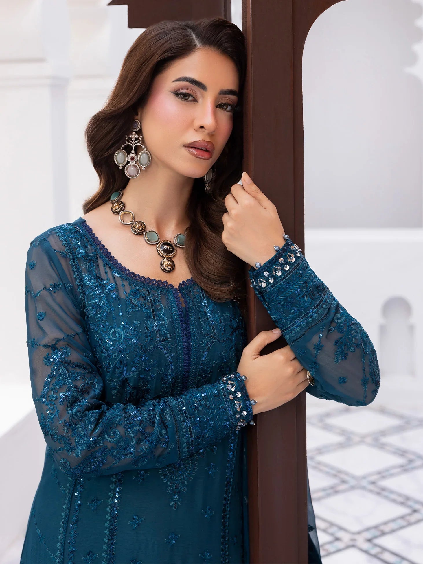"Focus on the intricate sleeve cuff trimmings and lace hemline details of the Gulaal Mist stitched luxury suit, showing boutique-quality tailoring."