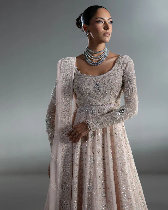 "Detailed view of the structured 12-panel flared kalidaar featuring heavy hemline border work paired with raw silk lehnga underskirt."