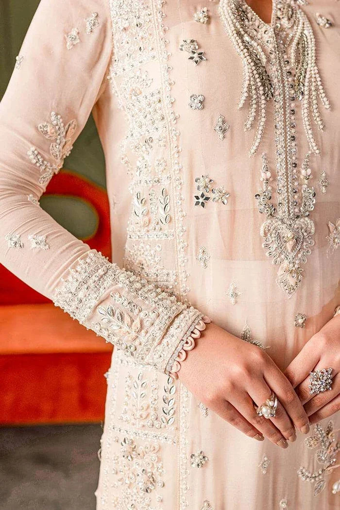 "Close-up of delicate pastel resham, floral threadwork, and subtle tilla embellishments on the Vera pale peach shirt neckline."