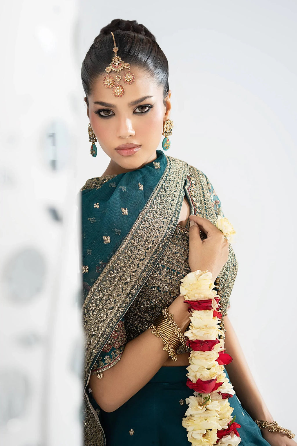 "Focus on the intricate sleeve cuff trimmings and embroidered hemline organza border details of the Maria B SF-EA26-27 Teal stitched luxury suit, showing boutique-quality tailoring."