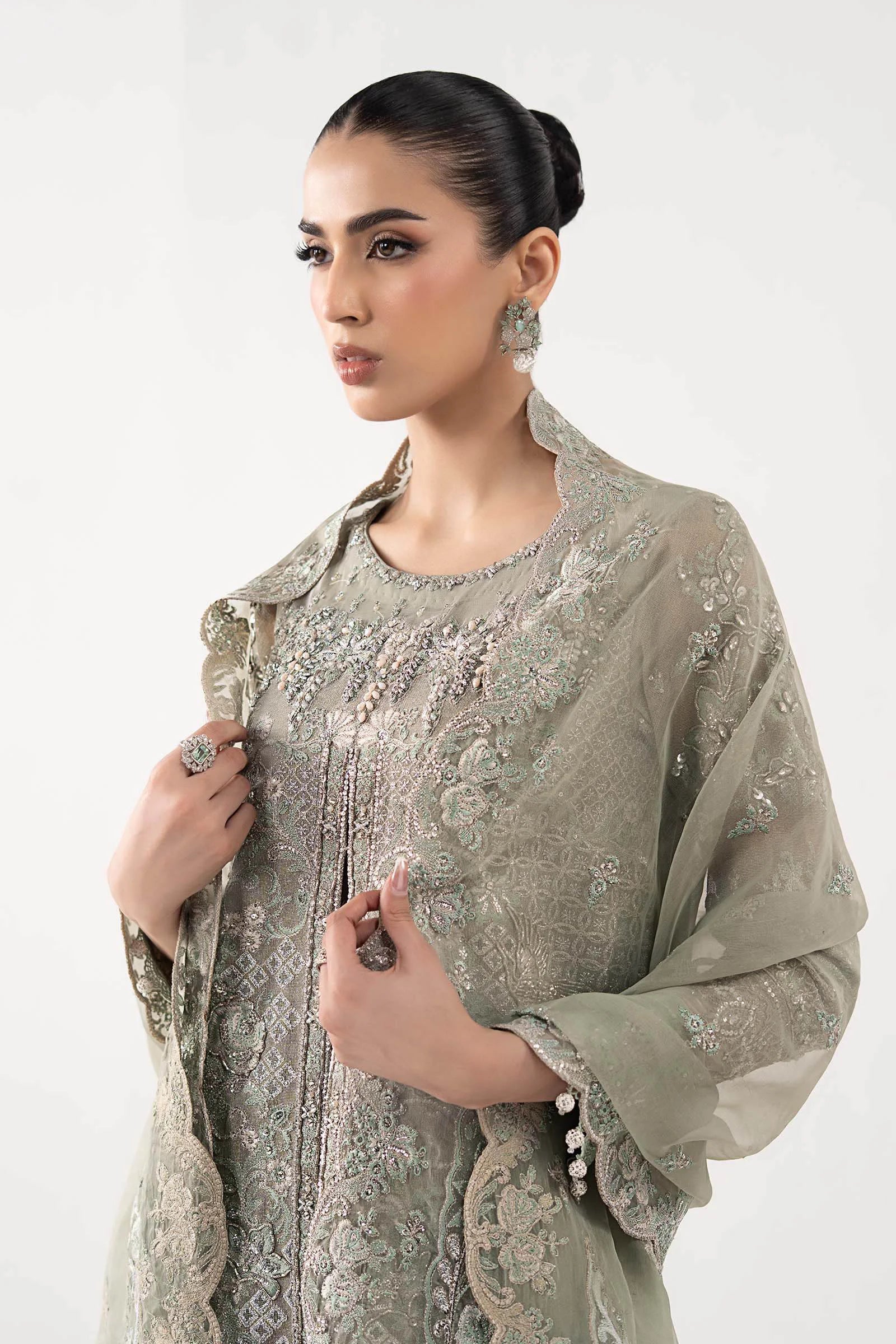 "Focus on the intricate sleeve cuff trimmings and embroidered hemline organza border details of the Maria B SF-W25-24 Sea Green stitched luxury suit, showing boutique-quality tailoring."
