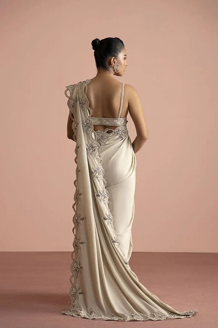 "Focus on the graceful back drape and sleeve finishing of the Vera white shimmer saree set."