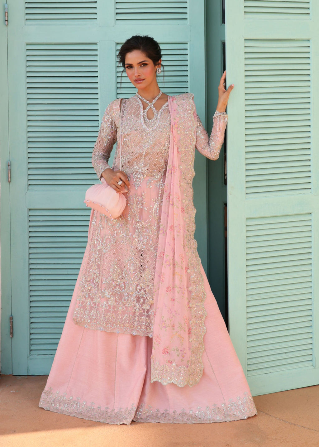 "Mirha Collections Kanwal Malik Marissa luxury three-piece Pakistani designer suit. Full-length presentation showcasing a striking deep crimson red embroidered lawn shirt with elaborate traditional layouts, paired with a matching rich printed silk dupatta and wide trousers."