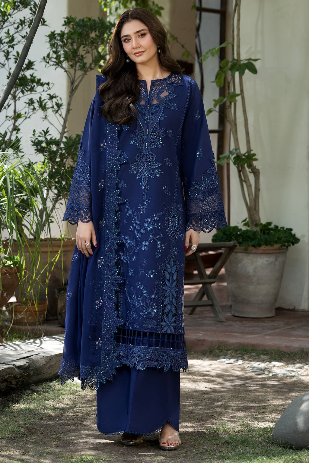 "Mirha Collections Motifz Campania Embroidered Lawn Unstitched three-piece designer suit. Full-length presentation showcasing an intricately embroidered lawn shirt paired with sleek tailored bottoms and a draped luxury dupatta."