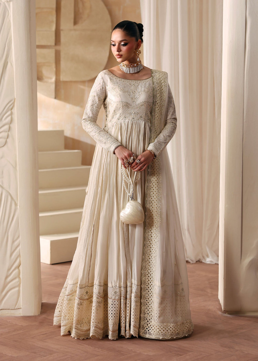 "Mirha Collections Kanwal Malik Nira luxury three-piece Pakistani designer suit. Full-length presentation of the premium ivory off-white tassel silk floor-length anarkali gown showcasing a heavily flared, pleated silhouette paired with a matching embroidered dupatta."