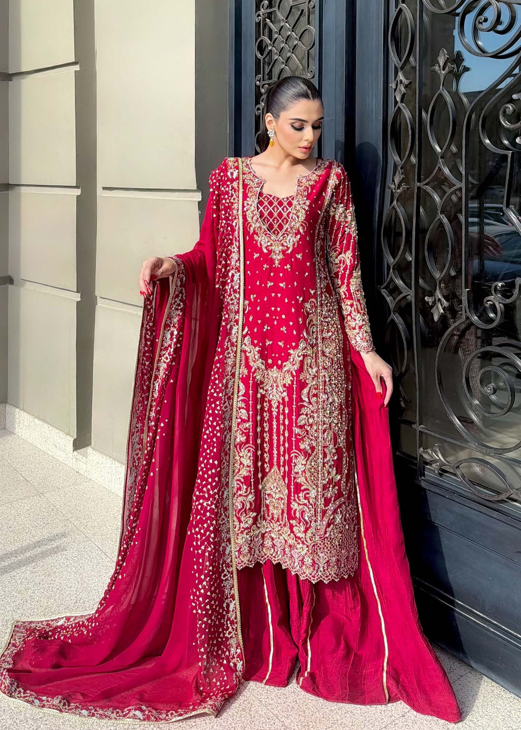 "Detailed view of the luxury magenta dupatta from the Kanwal Malik Aden collection, emphasizing the premium translucent drape, dense shimmer spray, and the neatly attached gold embroidered border trims."