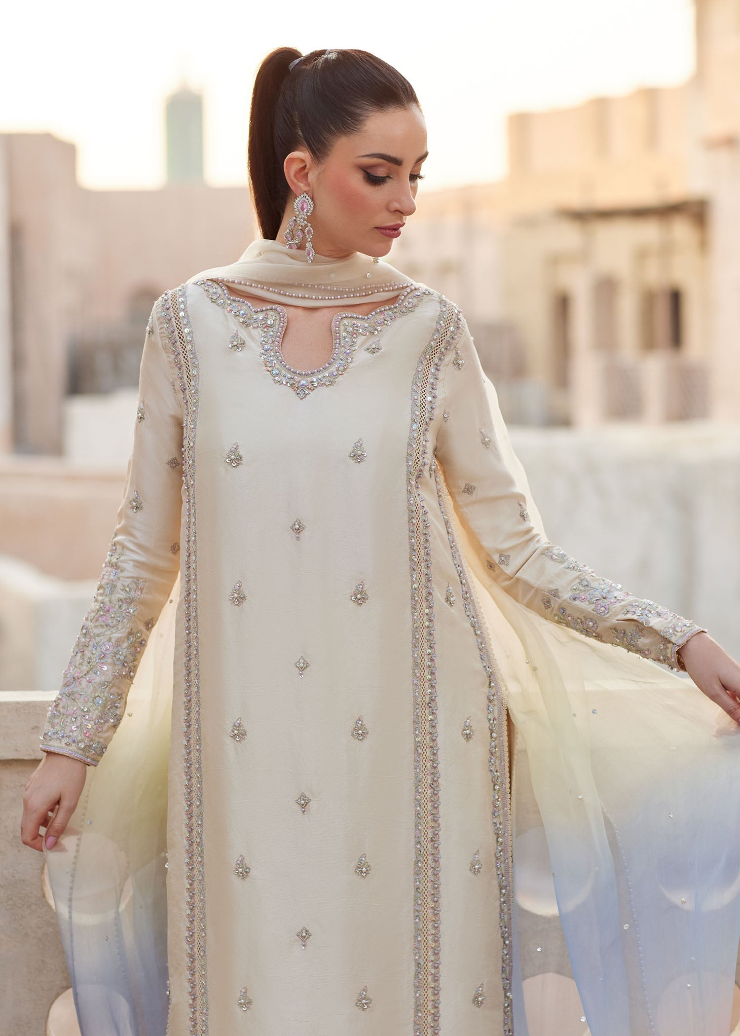 "Close-up premium craftsmanship on Kanwal Malik Reham ivory shirt, highlighting the heavy hand and machine embroidery on the prominent neckline, detailed sleeves, and intricate lace insertions across front panels."
