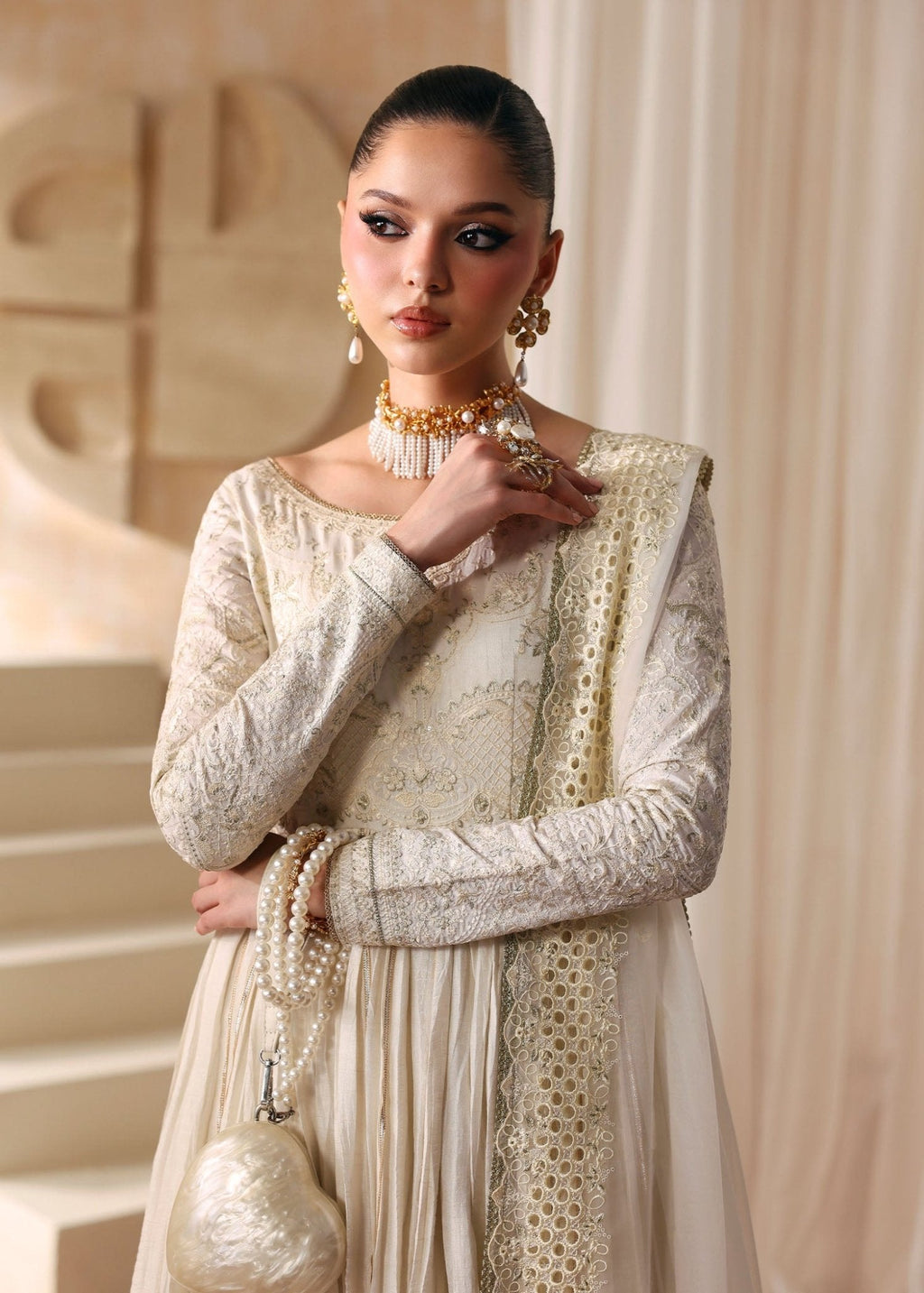 "Close-up premium detailing on Kanwal Malik Nira ivory dress, highlighting the delicate intricate hand embroidery on the bodice, long structured sleeves with artisan tilla work, and a classic wide boat neck layout."