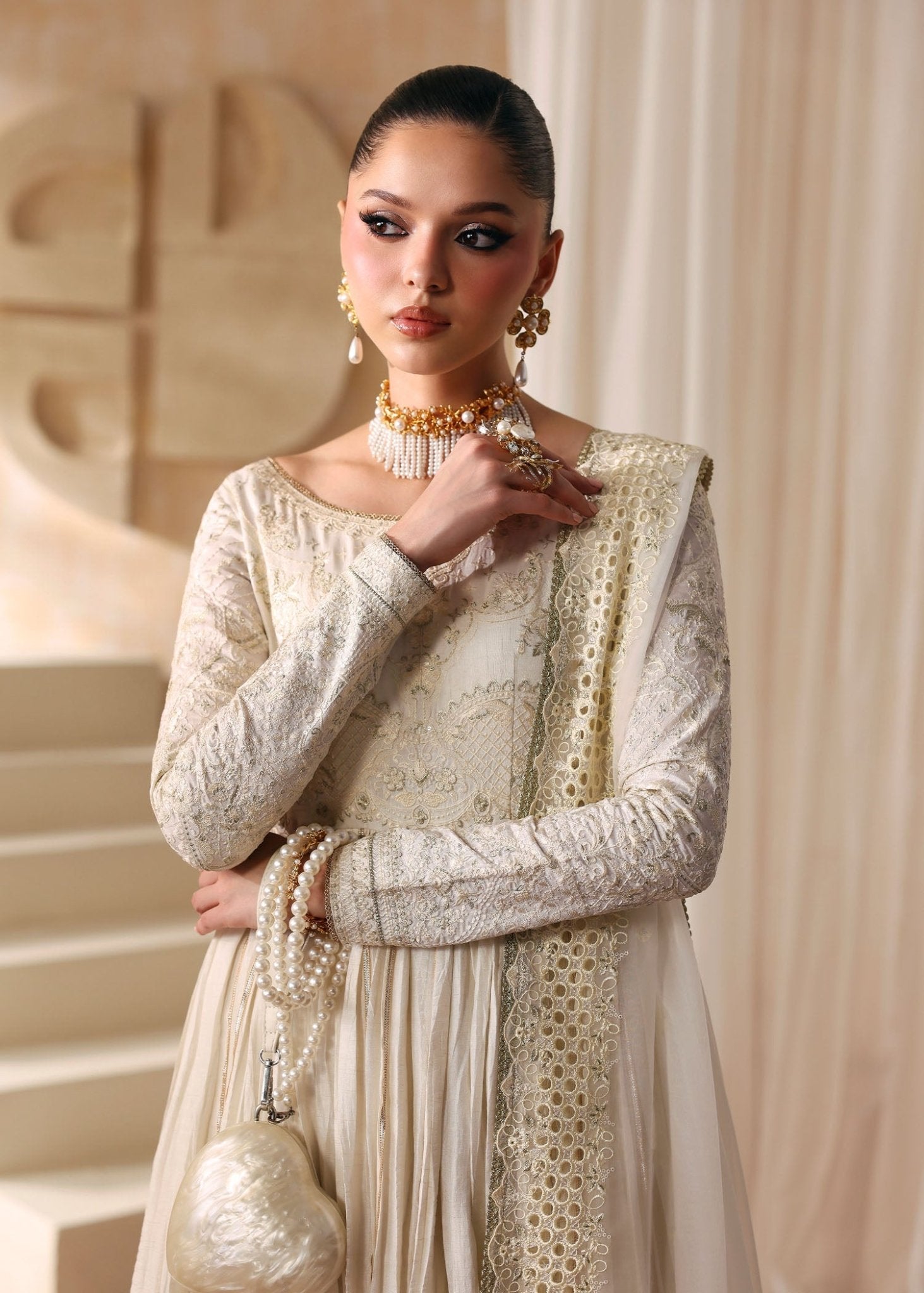 "Close-up premium detailing on Kanwal Malik Nira ivory dress, highlighting the delicate intricate hand embroidery on the bodice, long structured sleeves with artisan tilla work, and a classic wide boat neck layout."
