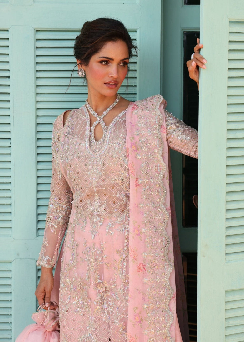 "Close-up premium detailing on the Kanwal Malik Marissa crimson lawn outfit, highlighting the heavy ivory and tilla floral threadwork embroidery on the central placket, neckline, and main shirt panels."