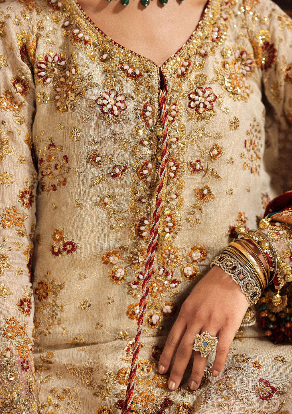 "Close-up Neck Line premium craftsmanship on Aik Wedding Festive Look A2603 dress, highlighting the intricate traditional Ada hand embellishments, sparkling crystal beadwork, and dense tilla layout along the neckline and front panels."
