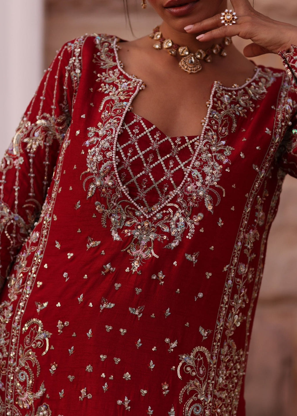"Neck Line view of the matching magenta gharara from the Kanwal Malik Aden ensemble, focusing on the rich fabric fall, panel design, and subtle gold lace insertions along the bottom flares."