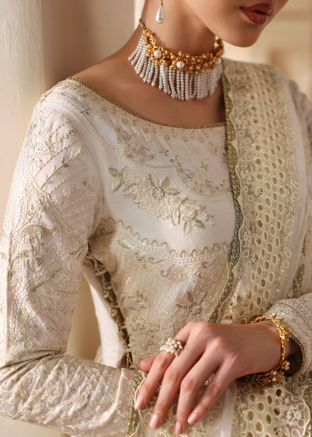 "Detailed shot of the lower skirt hemline from the Kanwal Malik Nira ensemble, focusing on the wide embroidered panels, geometric lace placements, and beautiful traditional eyelet cutwork border."