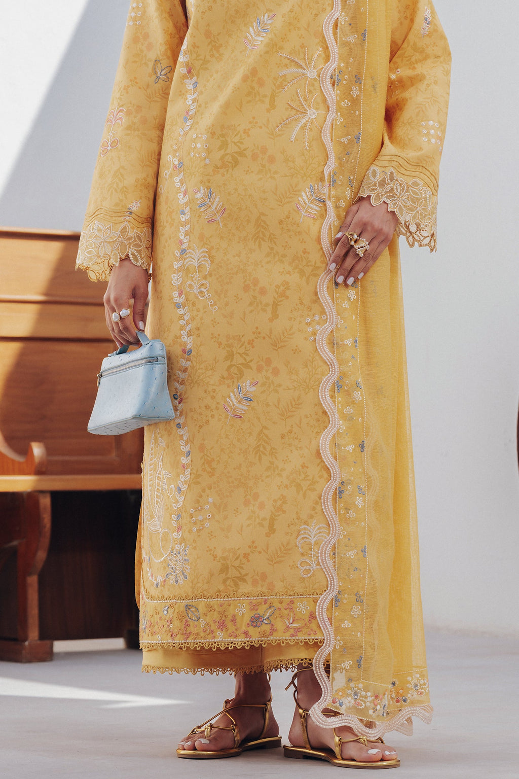 "Focus on the intricate sleeve cuff trimmings and lace hemline details of the Qalamkar QBP-06 CLARA stitched luxury suit, showing boutique-quality tailoring."