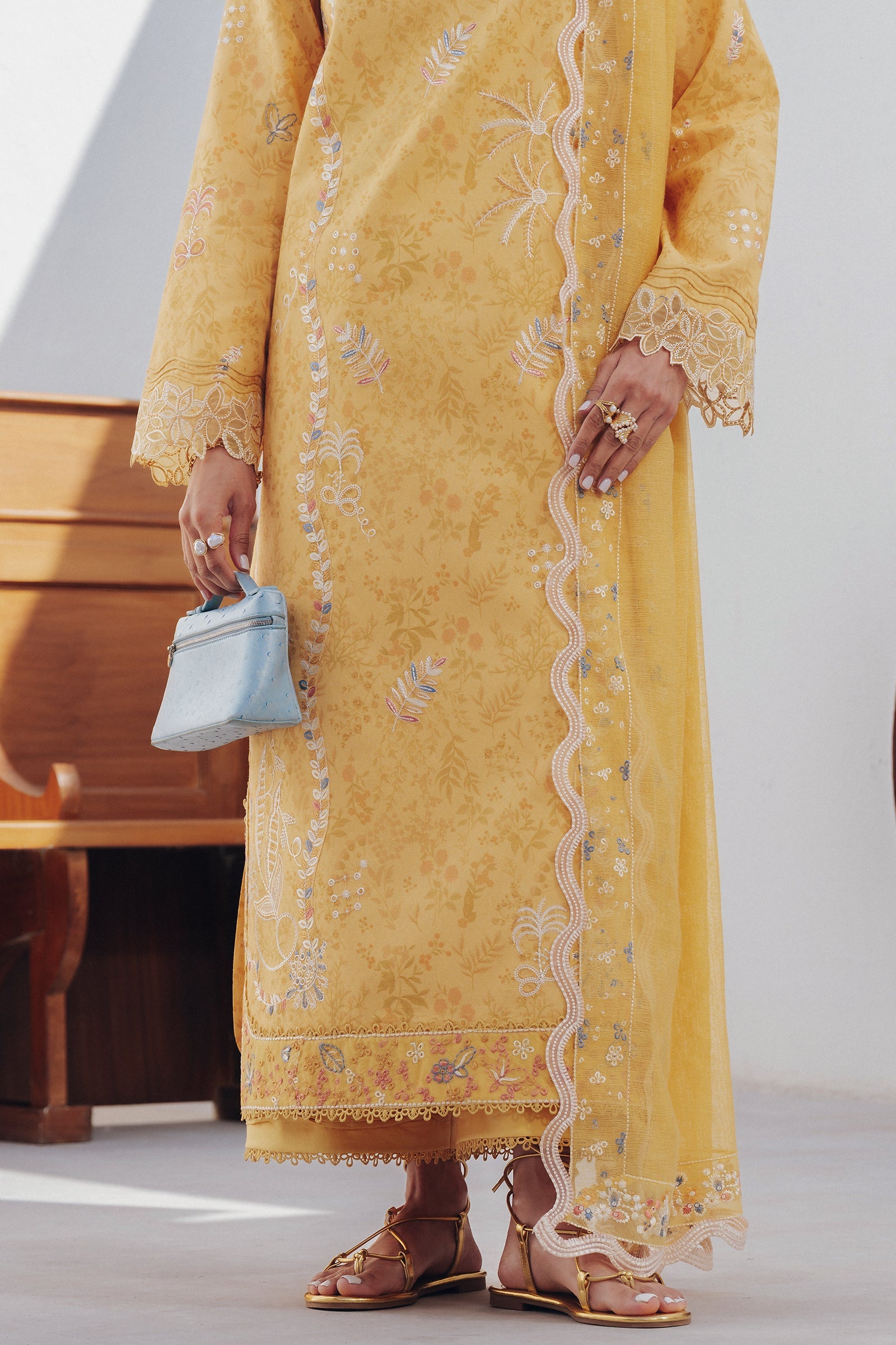 "Focus on the intricate sleeve cuff trimmings and lace hemline details of the Qalamkar QBP-06 CLARA stitched luxury suit, showing boutique-quality tailoring."