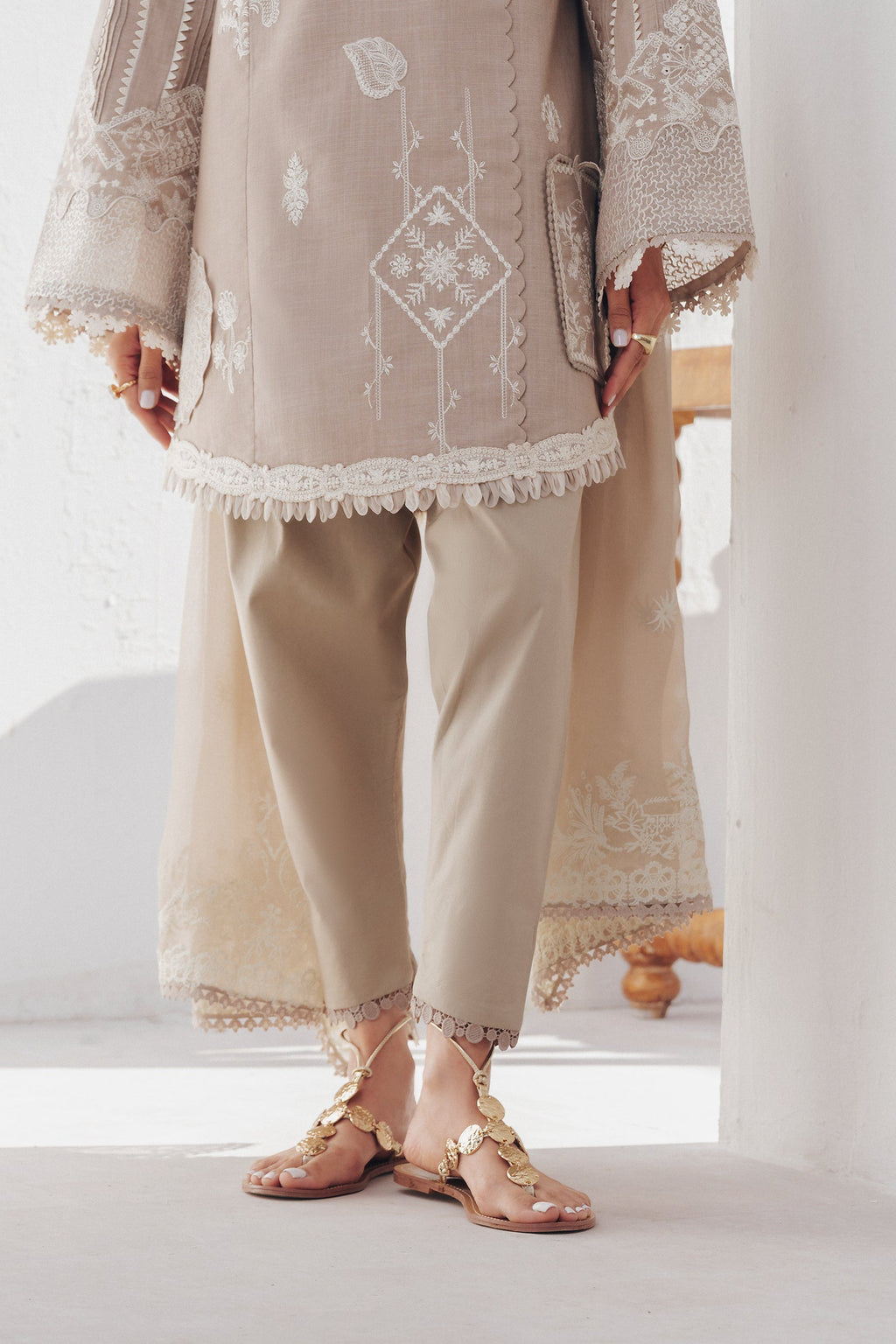 "Focus on the intricate sleeve cuff trimmings and lace hemline details of the Qalamkar QBP-08 ELKE stitched luxury suit, showing boutique-quality tailoring."