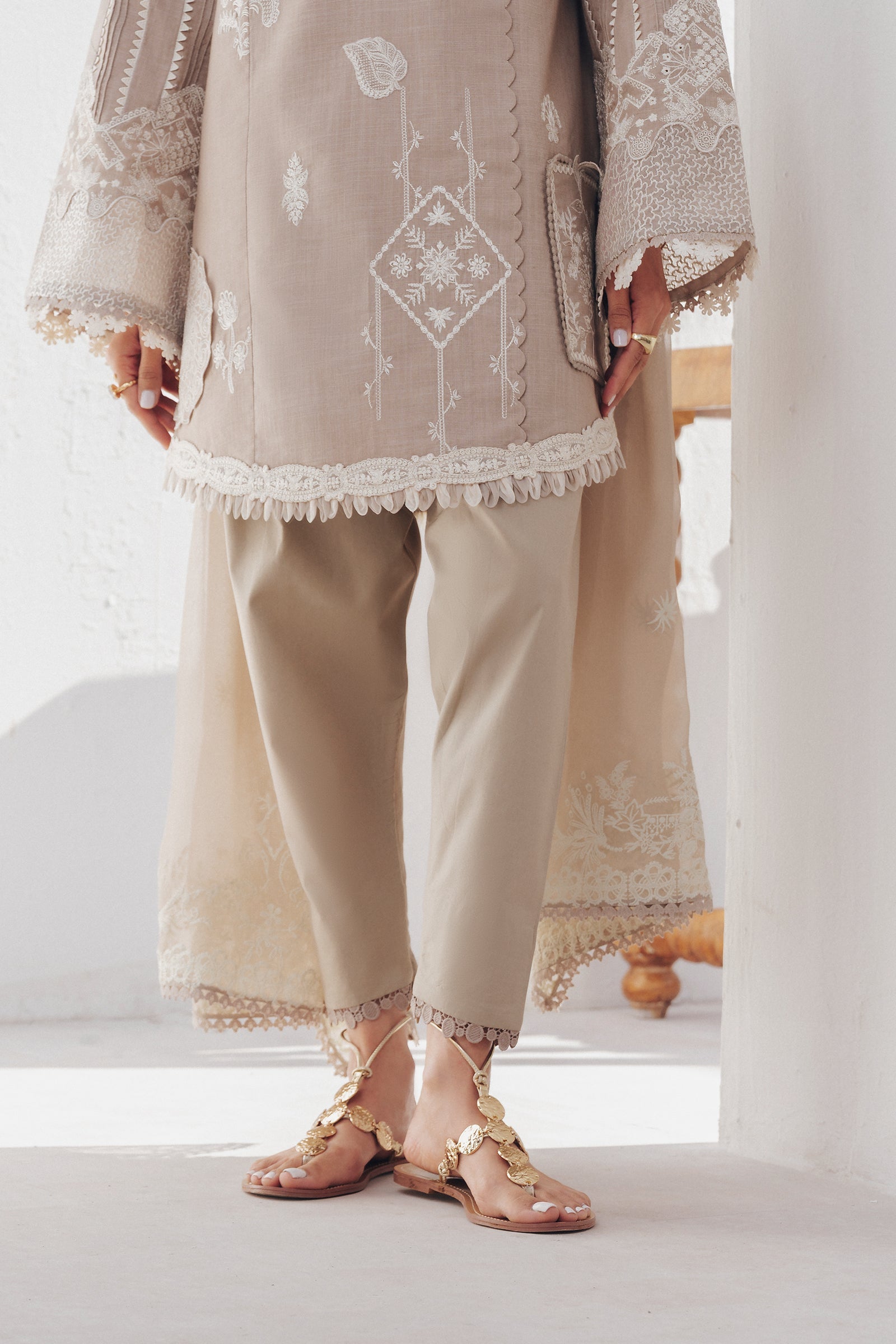 "Focus on the intricate sleeve cuff trimmings and lace hemline details of the Qalamkar QBP-08 ELKE stitched luxury suit, showing boutique-quality tailoring."