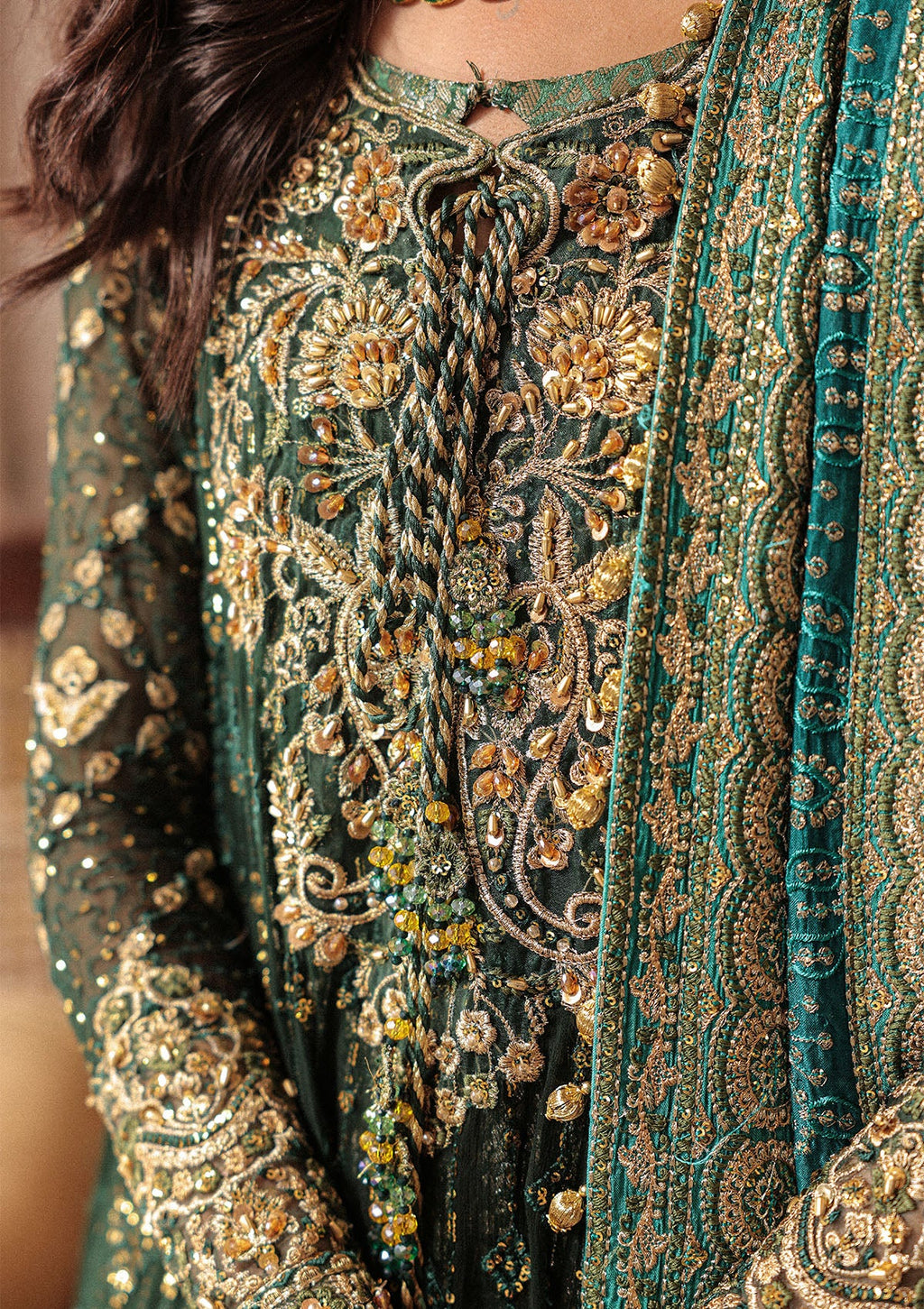 "another Close-up premium craftsmanship on Aik Wedding Festive Look A2604 dress, highlighting the intricate traditional Ada hand embellishments, sparkling crystal beadwork, and dense tilla layout along the neckline and front panels."