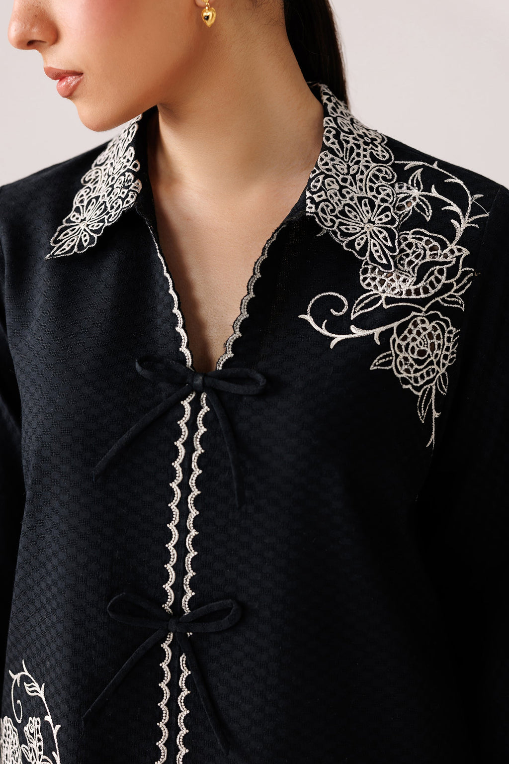 "Focus on the intricate sleeve cuff trimmings and lace hemline details of the Qalamkar QEC-02 Ana stitched luxury suit, showing boutique-quality tailoring."