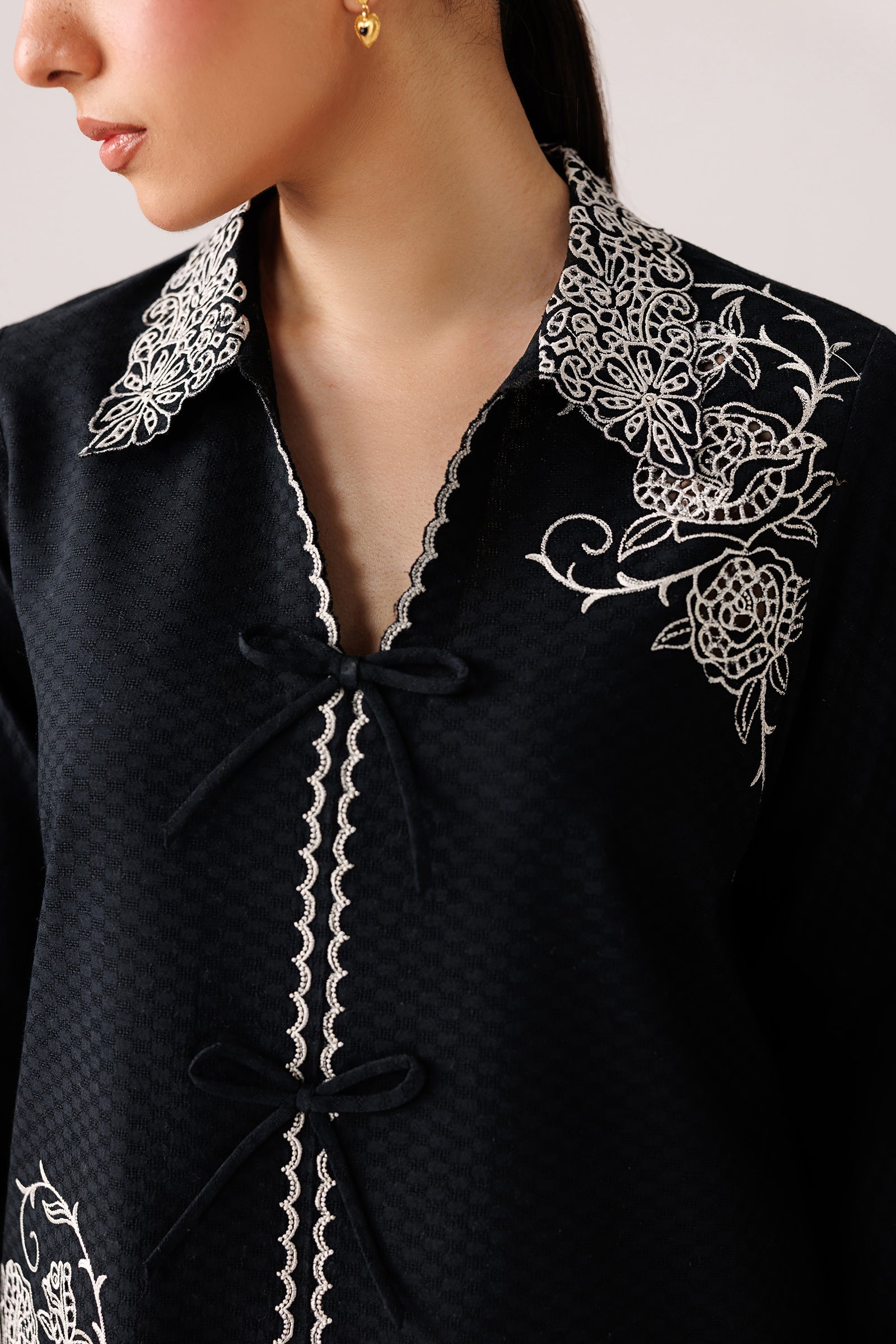 "Focus on the intricate sleeve cuff trimmings and lace hemline details of the Qalamkar QEC-02 Ana stitched luxury suit, showing boutique-quality tailoring."